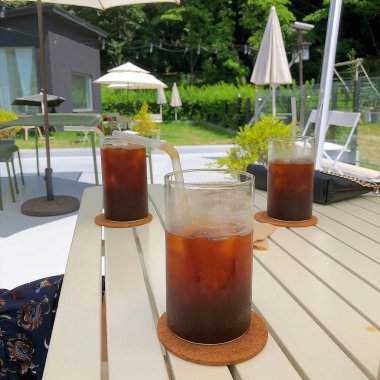 Bahçedeki ahşap masada bir bardak soğuk içecek.