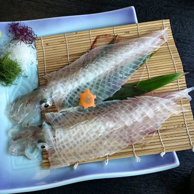 Tabağında limon olan çiğ somon balığı.