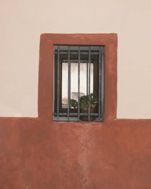Kırmızı duvarı ve ahşap çiti olan bir pencere.