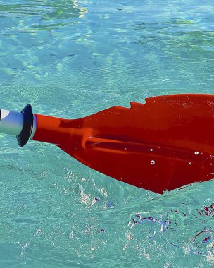 Mavi deniz suyu ve kırmızı dalgaların arka planında kırmızı su şişesi.