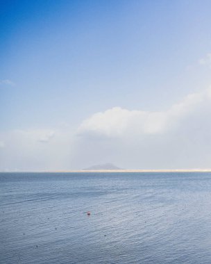 Uzakta beyaz bir kumla güzel bir deniz manzarasının dikey görüntüsü.
