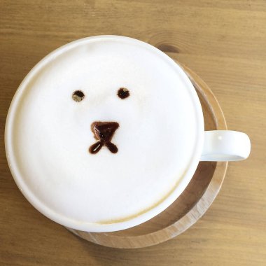 Bir fincan sıcak latte sanat kahvesi ve bir kedi.