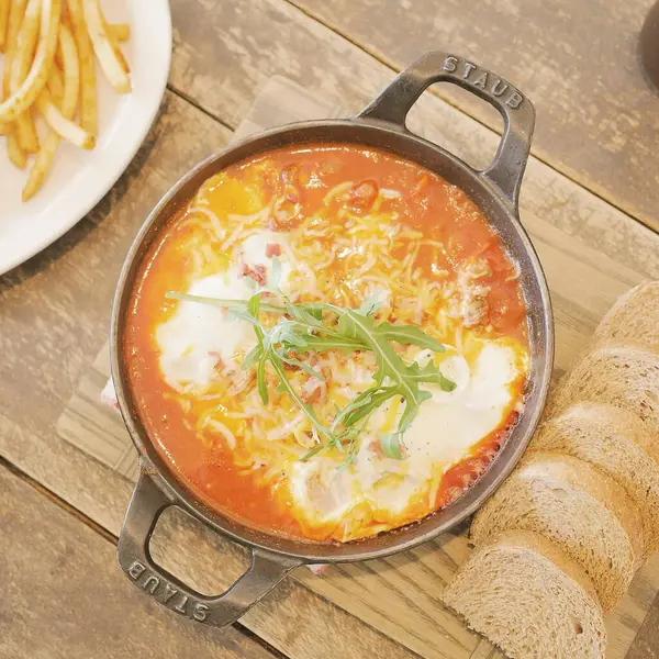 Tahta arka planda sosisli ve peynirli spagetti.