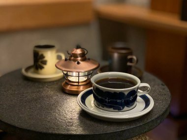 Kahve fincanı ve çay ahşap bir masada.