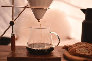 Tahta arka planda bir bardak su olan kahve makinesi..