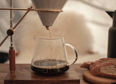 Kahve makinası, kahveyi ahşap masaya döküyor.