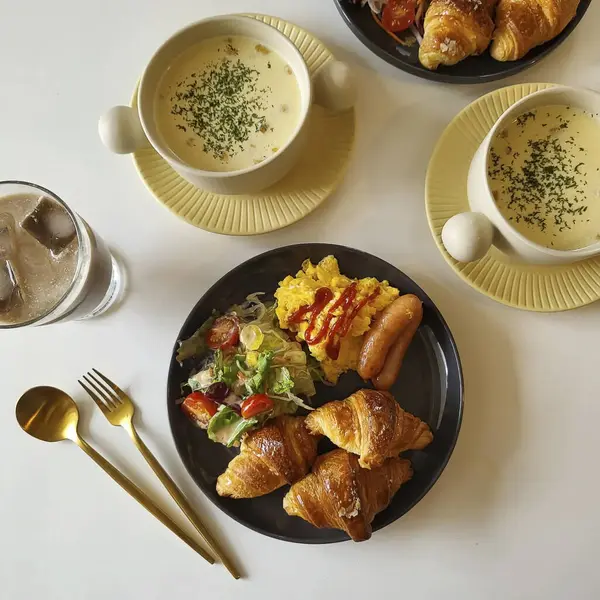 Tabakta bir fincan kahve ve ahşap bir masada bir bıçakla çekilmiş bir yemek fotoğrafı.