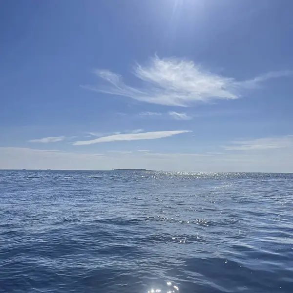 Beyaz bulutlu güzel mavi su yüzeyi.