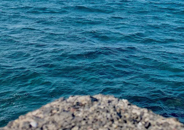 Dalgalar ve kayalarla dolu deniz suyu yüzeyi