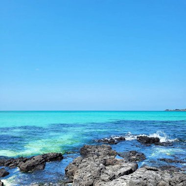 Kayalık sahili olan güzel bir deniz manzarası.