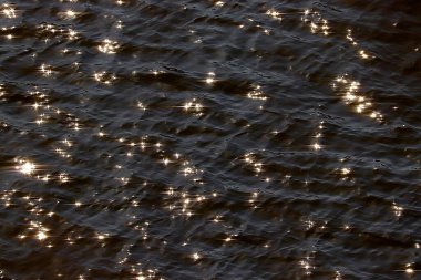 Dalgalar ve güneş yansımalarıyla deniz suyu yüzeyi