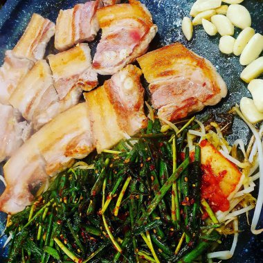 Baharatlı domuz göbeği ve siyah tabakta otlar. Üst görünüm, kapat - kapat