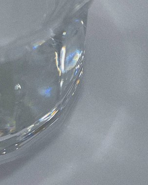 Gri zemin üzerinde beyaz bir damla su bulunan cam şeffaf su, yakın çekim. soyut arkaplan