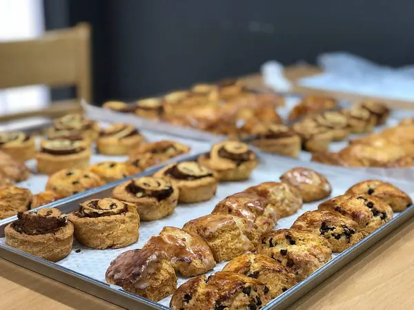 Tahta bir masada bir sürü taze hamur işi ve çikolata.