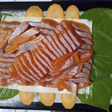 Tahta tepside dilimlenmiş somon ve somon.