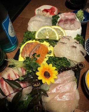 Siyah arka planda sebzeli ve baharatlı çiğ balık