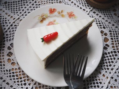 Kremalı lezzetli pasta ve beyaz tabakta böğürtlen