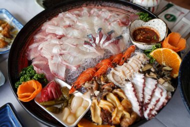 Deniz ürünleri, taze balık, karides ve diğer yemekler masada..