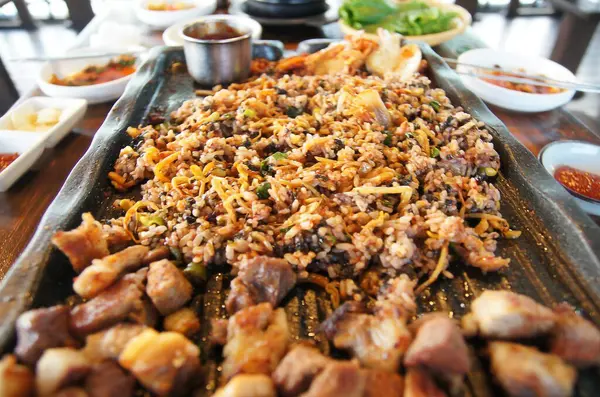 Kızarmış domuz ve pilav masada.