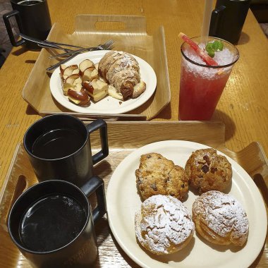 Bir fincan çay, yanında kruvasan ve kek.