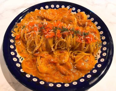 Köfteli spagetti, domates sosu ve beyaz tabakta parmesan.