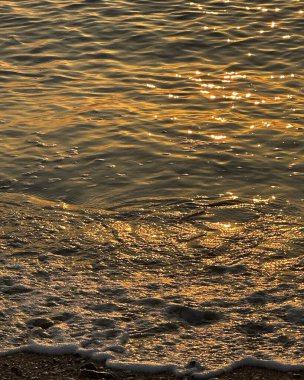 Dalgalar ve dalgalarla denizlerde güzel altın gün batımı