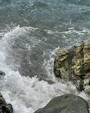 Deniz kıyısındaki kayalıklarda dalgalar.