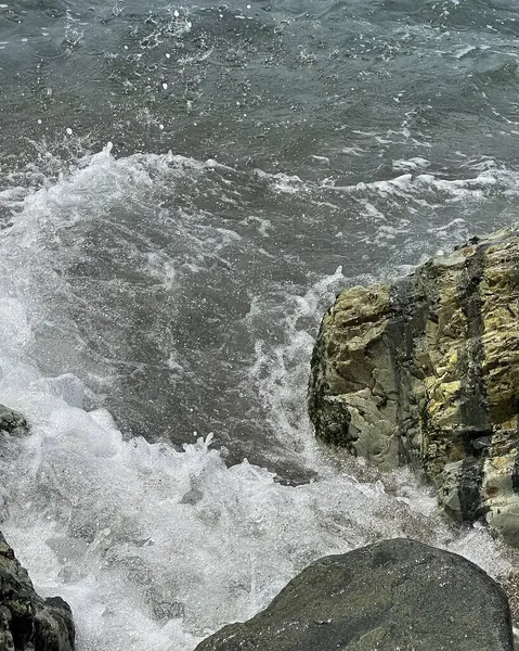 Deniz kıyısındaki kayalıklarda dalgalar.