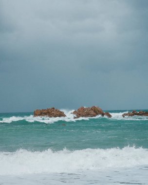 Arka planda dalga olan bir denizin dikey görüntüsü.