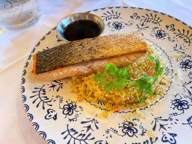 Sebzeli, baharatlı ve soslu ızgara somon bifteği.