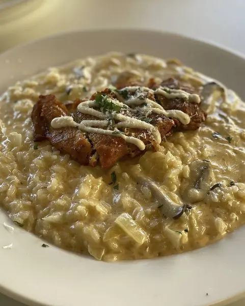 Tabağında peynir ve mantarlı makarnanın yakın plan fotoğrafı.