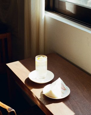 Bir fincan çay, bir bardak süt ve bir fincan kahveyle ahşap bir masada.