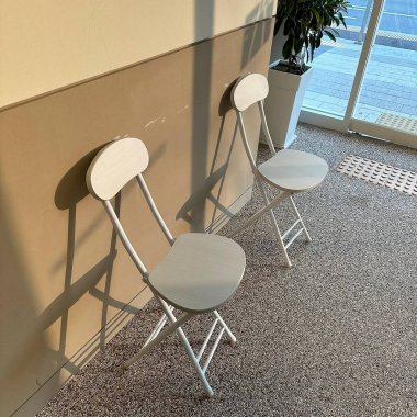 Bir binanın duvarında boş bir sandalye.