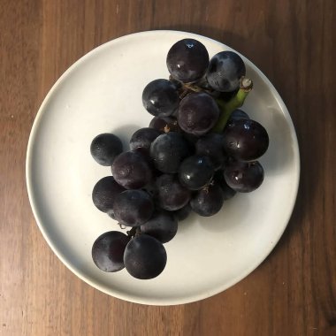 Beyaz ahşap arka planda taze üzümler.