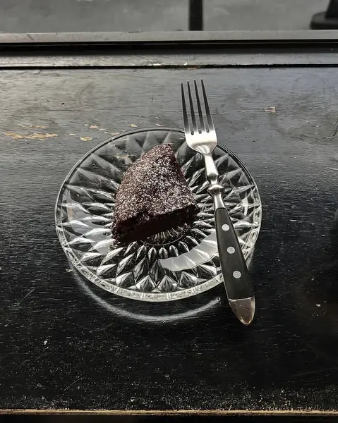 Tabağında çatal olan bir parça çikolatalı pasta.