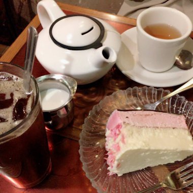 a cup of tea with a white saucer and a glass of milk