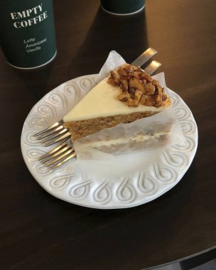 Bir parça çatallı kek ve masada bir fincan kahve.