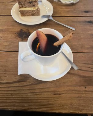 Bir bardak çay, bir fincan kahve ve masanın üstünde bir fincan kahve.