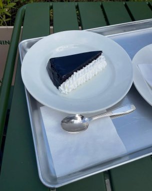 Kremalı bir parça çikolatalı pasta ve tabakta bıçak.