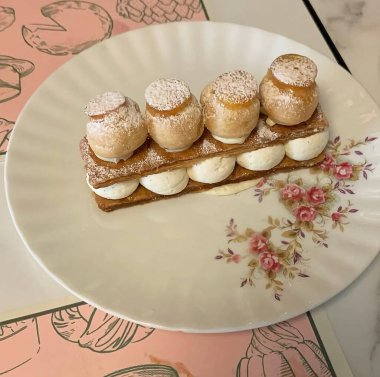 Beyaz bir yüzey üzerinde lezzetli pastalar olan bir tabağın dikey görüntüsü.