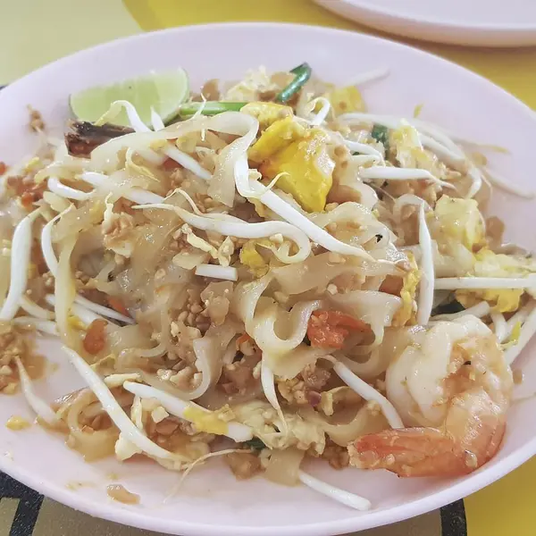 Karidesli kızarmış erişte ve beyaz tabakta yumurta.