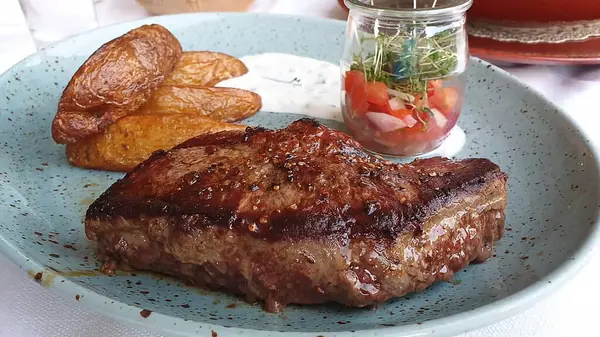 Biftek ve patates kızartması masada.