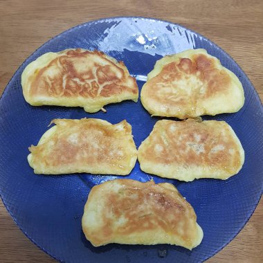 Tahta bir arka planda bıçakla tabakta gözleme..