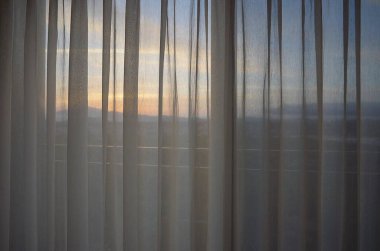 Şehirde perdeleri ve perdeleri olan bir pencere.