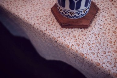 Tahta arka planda kaşık olan bir fincan kahve.