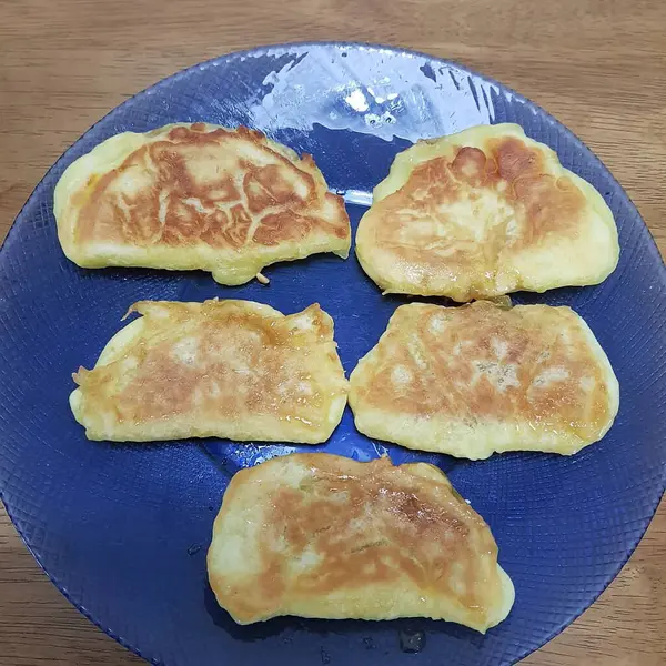 Tahta bir arka planda bıçakla tabakta gözleme..