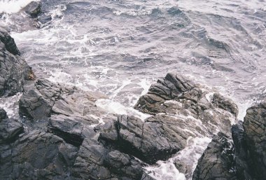 Dalgalar ve köpük sahilde