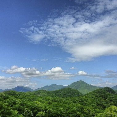 Dağları ve mavi gökyüzü olan güzel bir manzara.