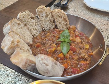 Bir tabak dolusu domatesli ve fesleğenli lezzetli ekmeğin yakın çekimi.