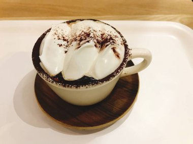 Çikolatalı kahve fincanı ve ahşap arka planda dondurma.